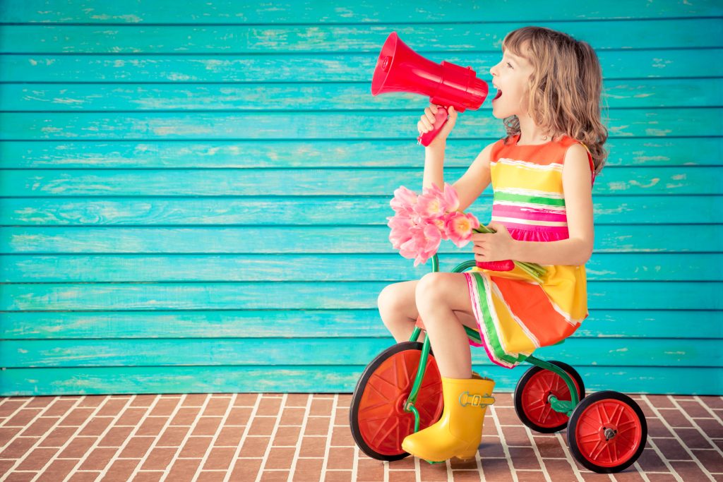 girl on bike with bullhorn speaking something into it.